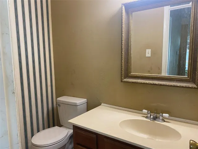 a bathroom with a sink a toilet and mirror