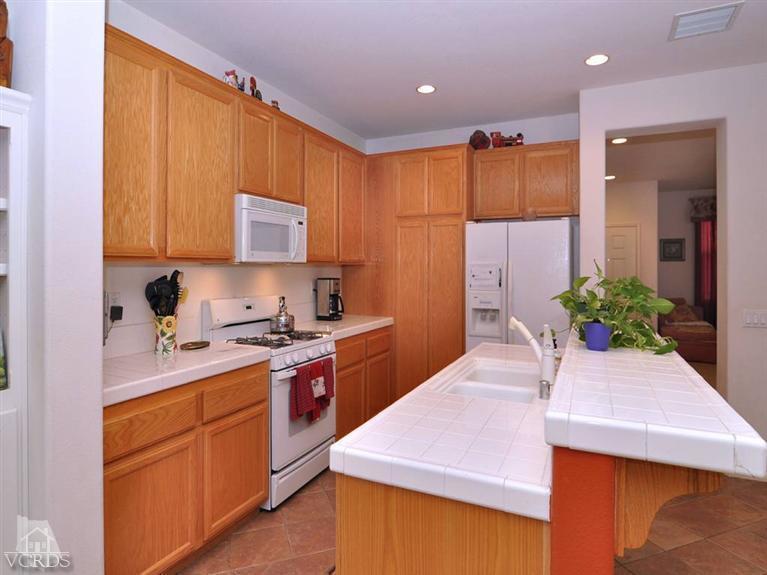 a kitchen with stainless steel appliances kitchen island sink refrigerator and stove