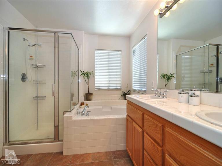 2547 Canterbury Lane Simi Valley, CA 93063 - Photo 12 of 12 a bathroom with a double vanity sink a mirror a bathtub and shower