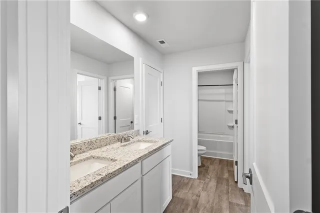 a white toilet sitting next to a bath tub