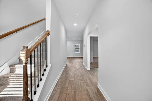a view of a hallway with wooden floor and staircase