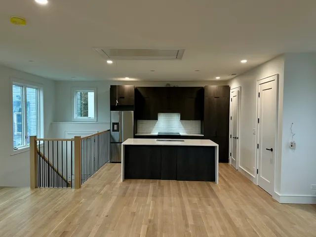 a living room with a bed and a wooden floor