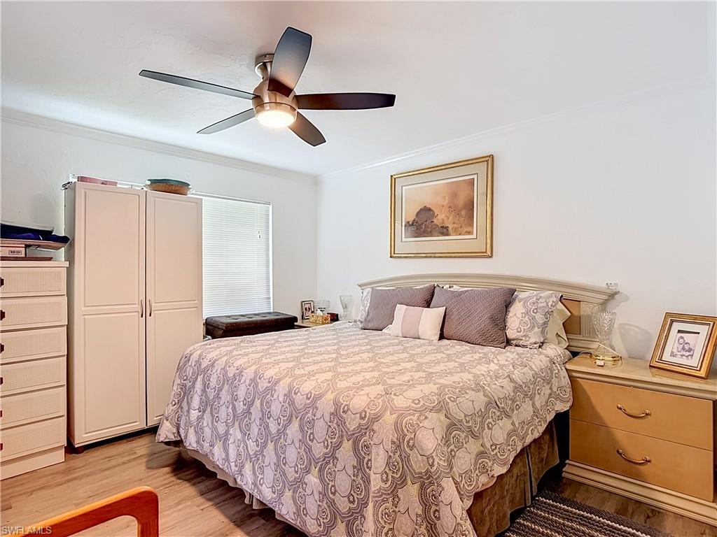 2280 Capri Court Naples, FL 34105 - Photo 16 of 49 a bedroom with a large bed and a chandelier