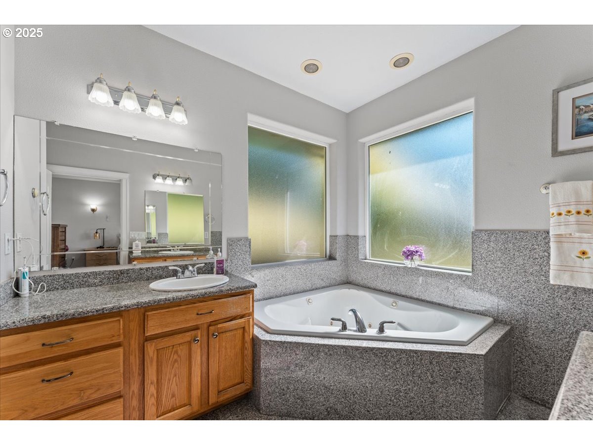 5122 Southeast Jenne Road Portland, OR 97236 - Photo 21 of 36 a bathroom with a granite countertop sink mirror and bathtub