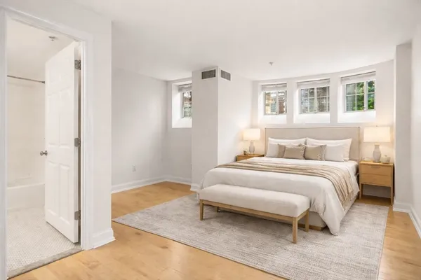 a spacious bedroom with a bed and a window
