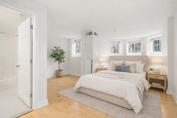 a bedroom with a large bed and a potted plant