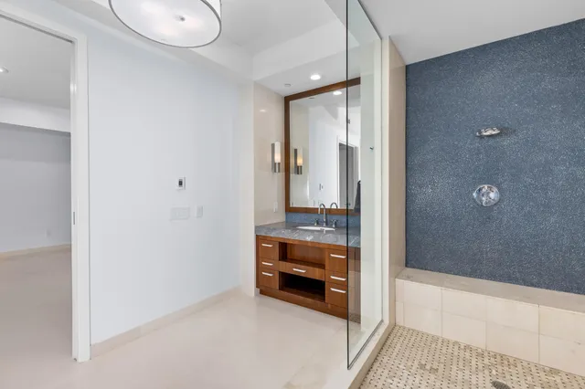 a bathroom with a granite countertop sink and a mirror
