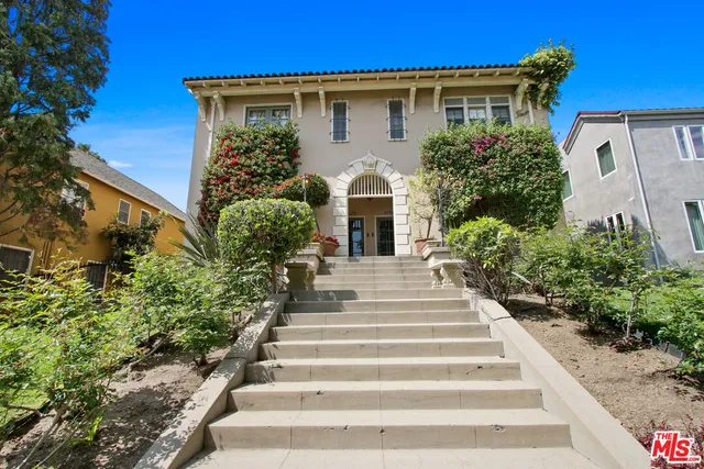 a front view of a house with potted plants