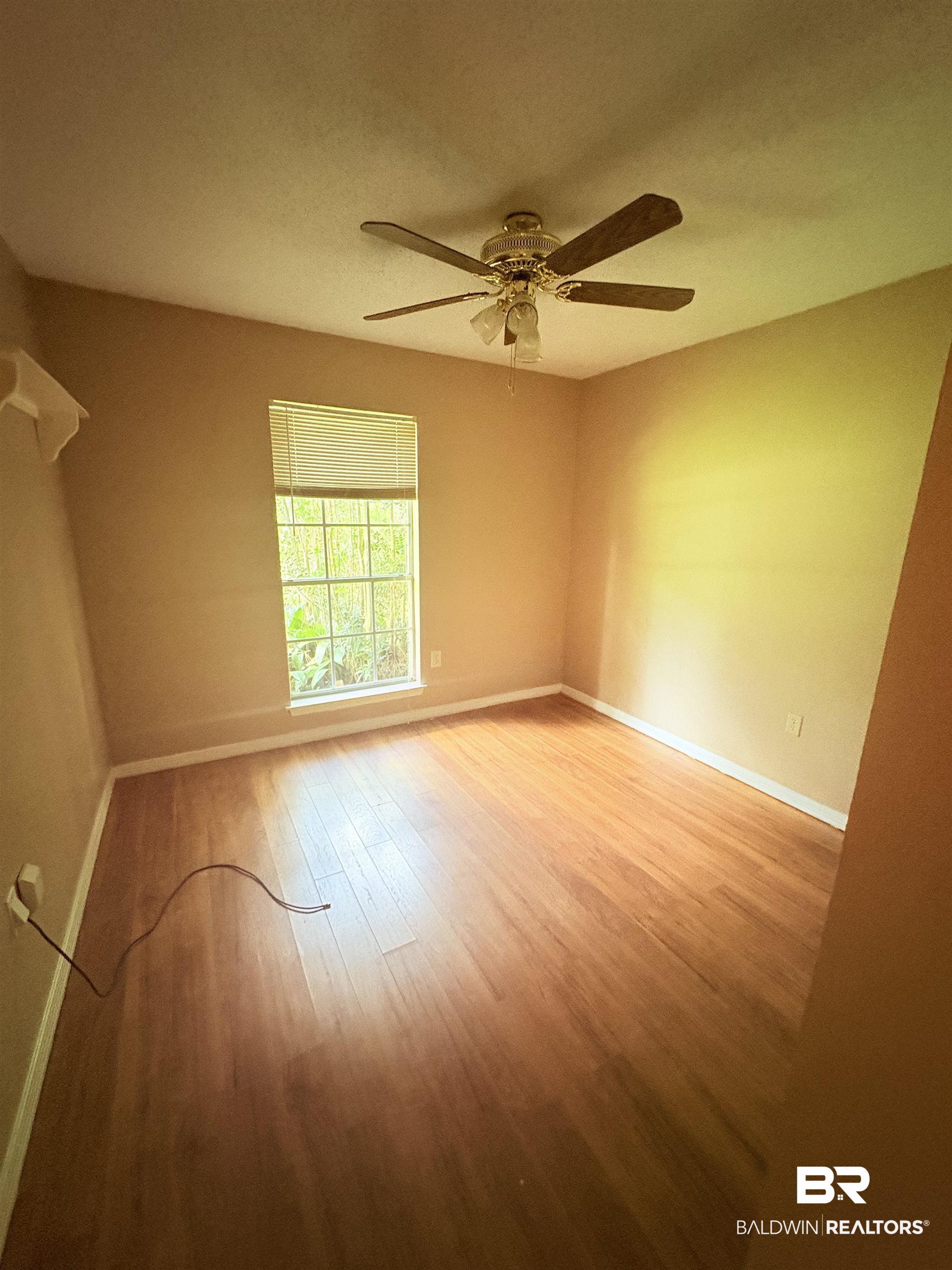 8070 Middle Ring Road Mobile, AL 36619 - Photo 26 of 26 Empty room with wood finished floors and ceiling fan