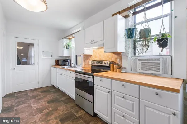 a kitchen with granite countertop white cabinets and window