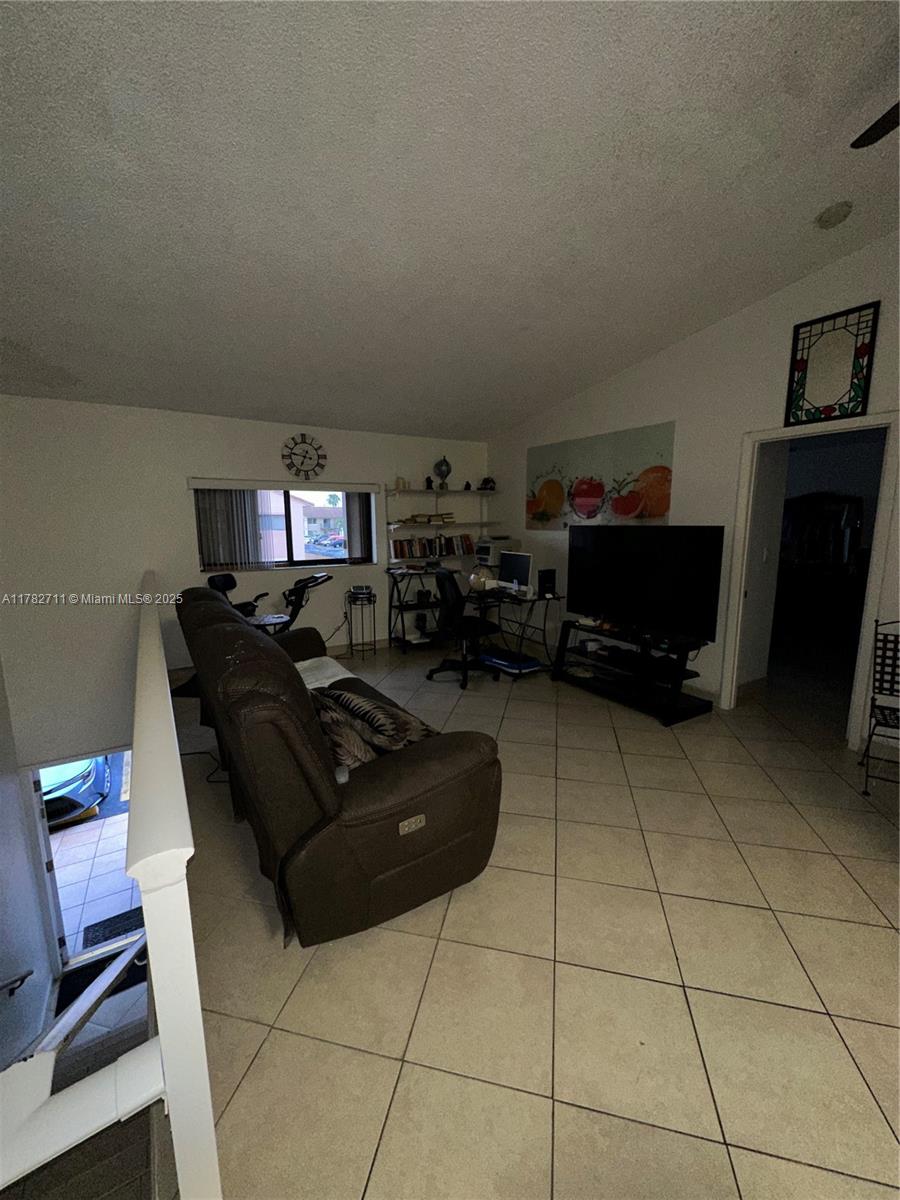 7795 West 29th Way, Unit 201 Hialeah, FL 33018 - Photo 12 of 15 a living room with furniture and a flat screen tv