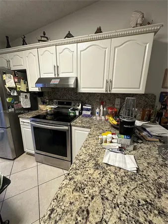 a kitchen with stainless steel appliances granite countertop a sink and a stove