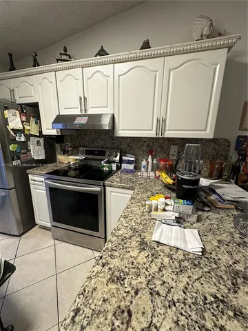 a kitchen with stainless steel appliances granite countertop a sink and a stove