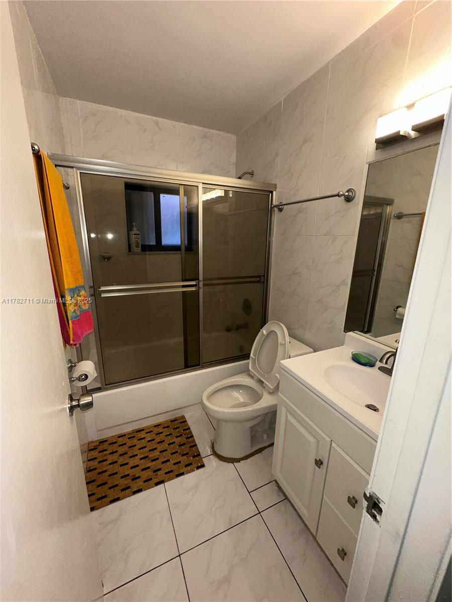 7795 West 29th Way, Unit 201 Hialeah, FL 33018 - Photo 7 of 15 a bathroom with a toilet a sink a shower and mirror