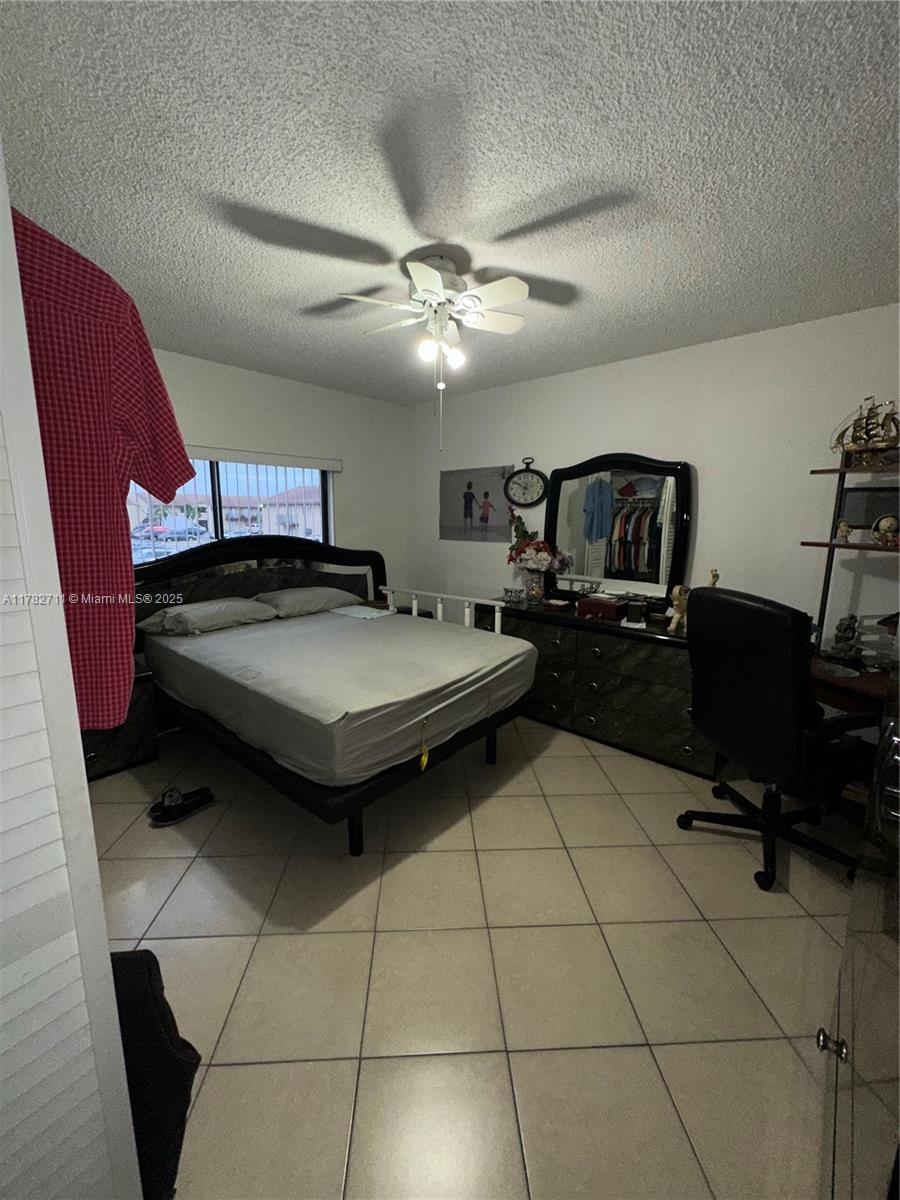 7795 West 29th Way, Unit 201 Hialeah, FL 33018 - Photo 9 of 15 a bedroom with a bed and a chandelier