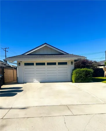 a view of house with backyard and bushes