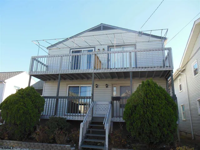a wooden house with a large window and wooden fence