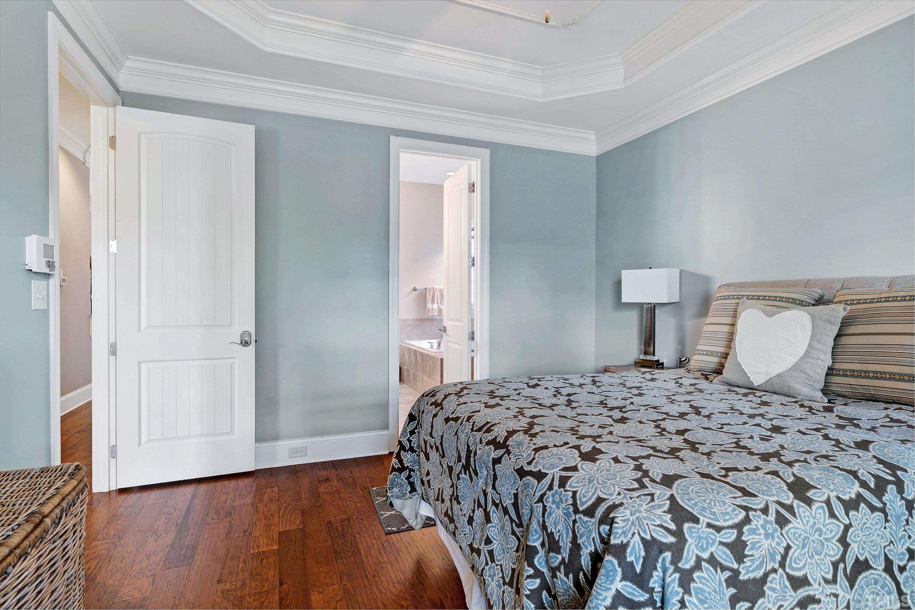 1001 Ambergate Station Apex, NC 27502 - Photo 18 of 49 a bedroom with a bed and wooden floor