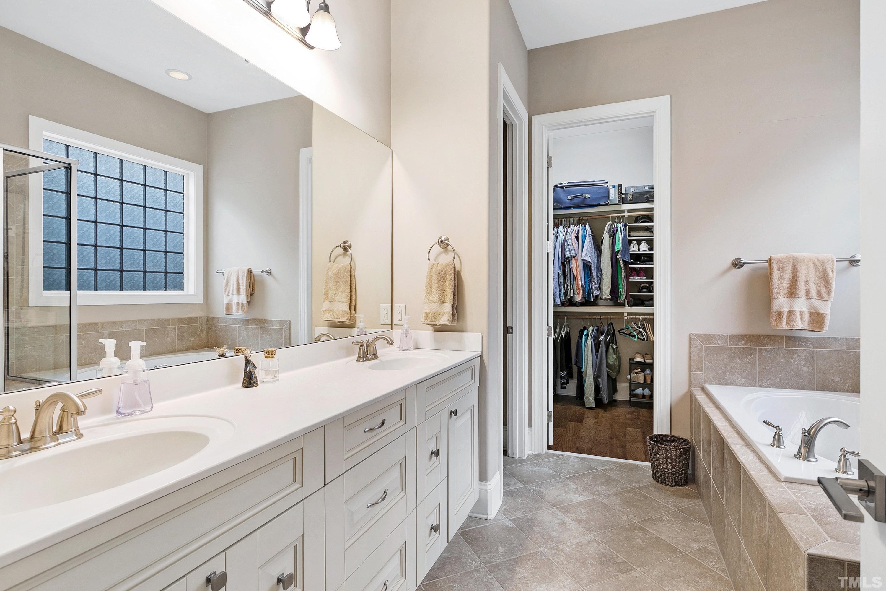 1001 Ambergate Station Apex, NC 27502 - Photo 19 of 49 a bathroom with a tub sink and mirror