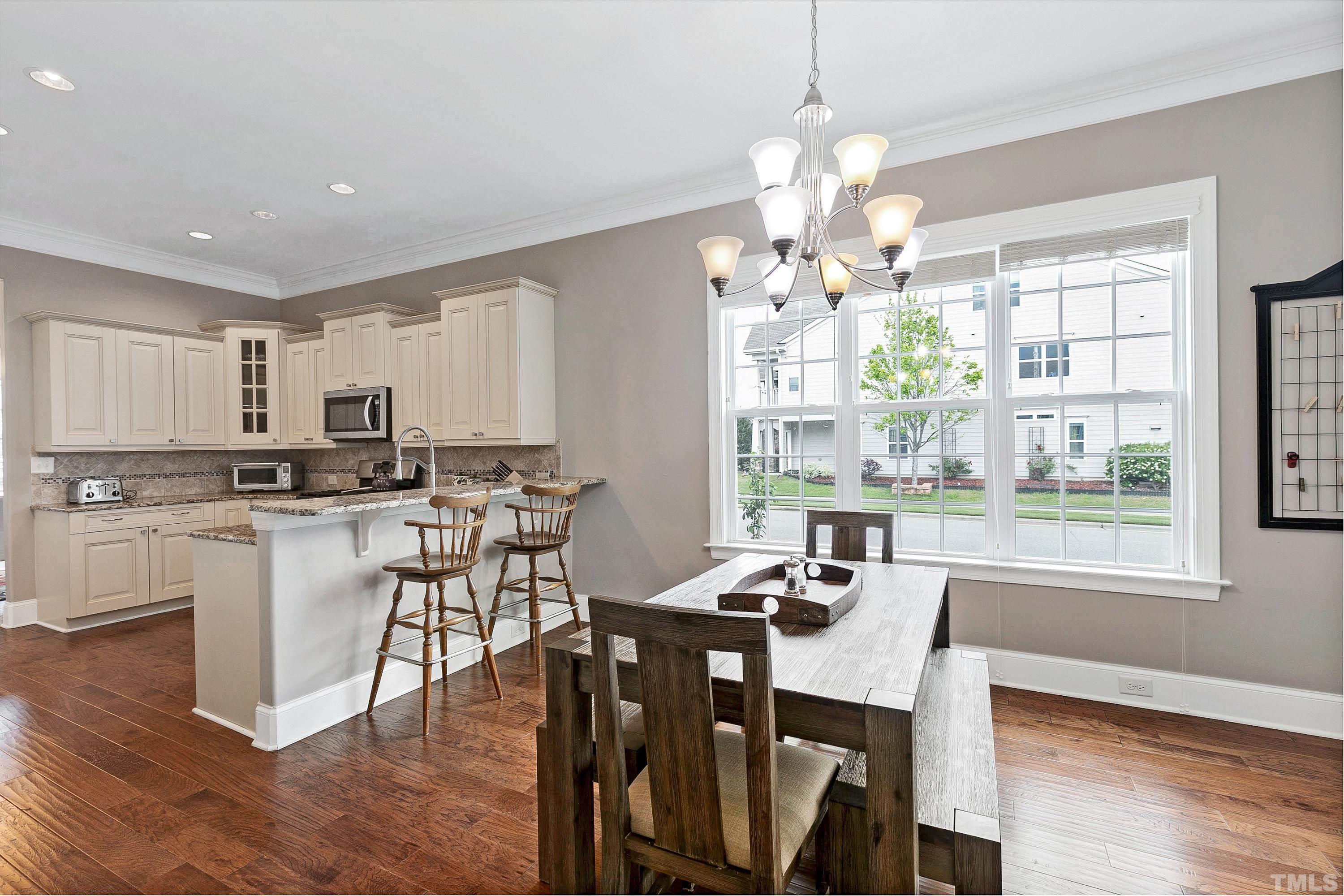 1001 Ambergate Station Apex, NC 27502 - Photo 8 of 49 a view of a dining room with furniture a chandelier and wooden floor