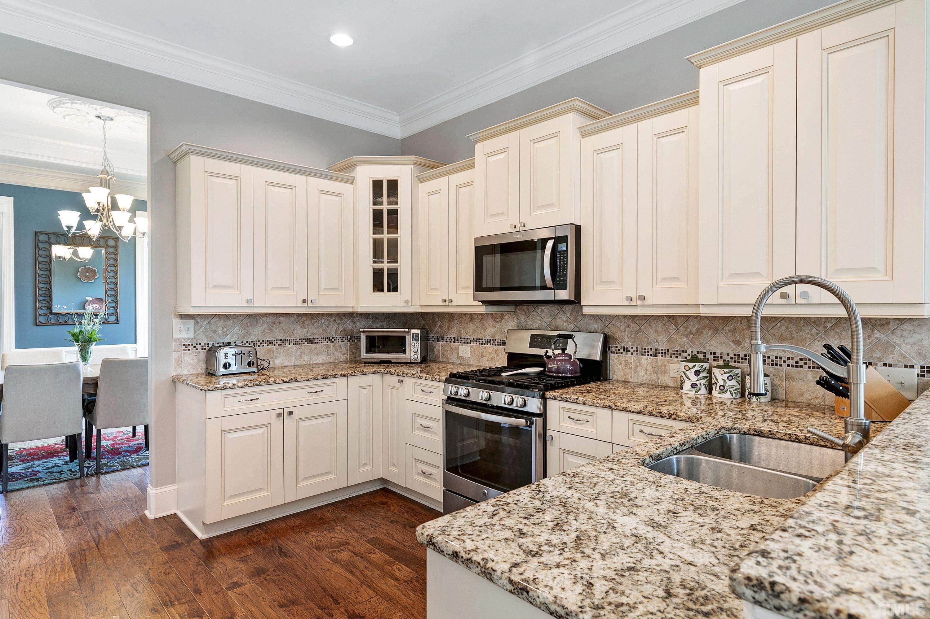 1001 Ambergate Station Apex, NC 27502 - Photo 10 of 49 a kitchen with white cabinets sink and stainless steel appliances