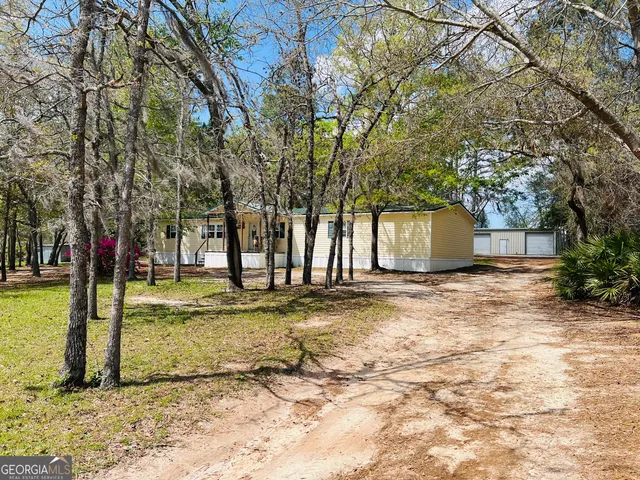 a view of a yard with a house and large tree