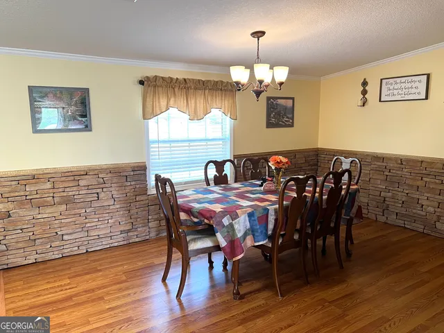 a view of a dining room with furniture wooden floor and chandelier