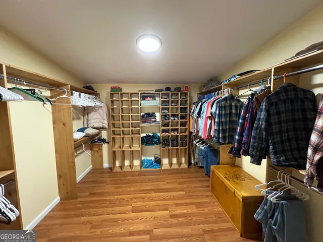 a view of walk in closet with clothes and shoes