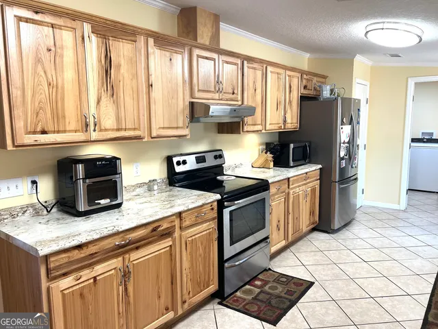 a kitchen with granite countertop a stove a sink dishwasher and a refrigerator