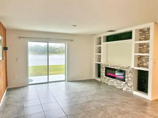 a view of an empty room with furniture and a fireplace