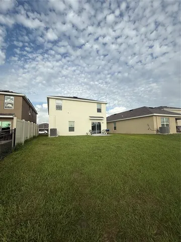 a backyard of a house with lots of green space and fountain