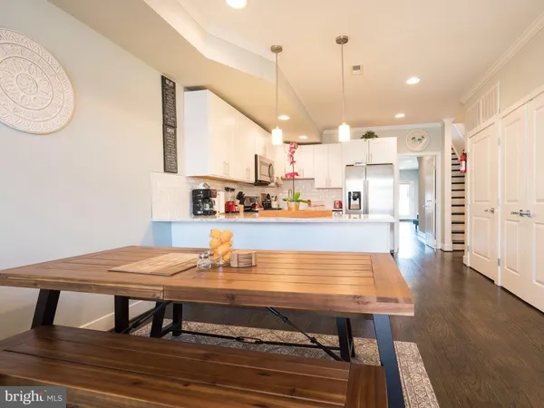 a dining table sitting next to a counter top with stainless steel appliances