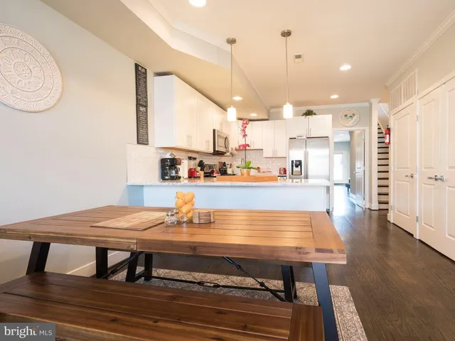 a dining table sitting next to a counter top with stainless steel appliances