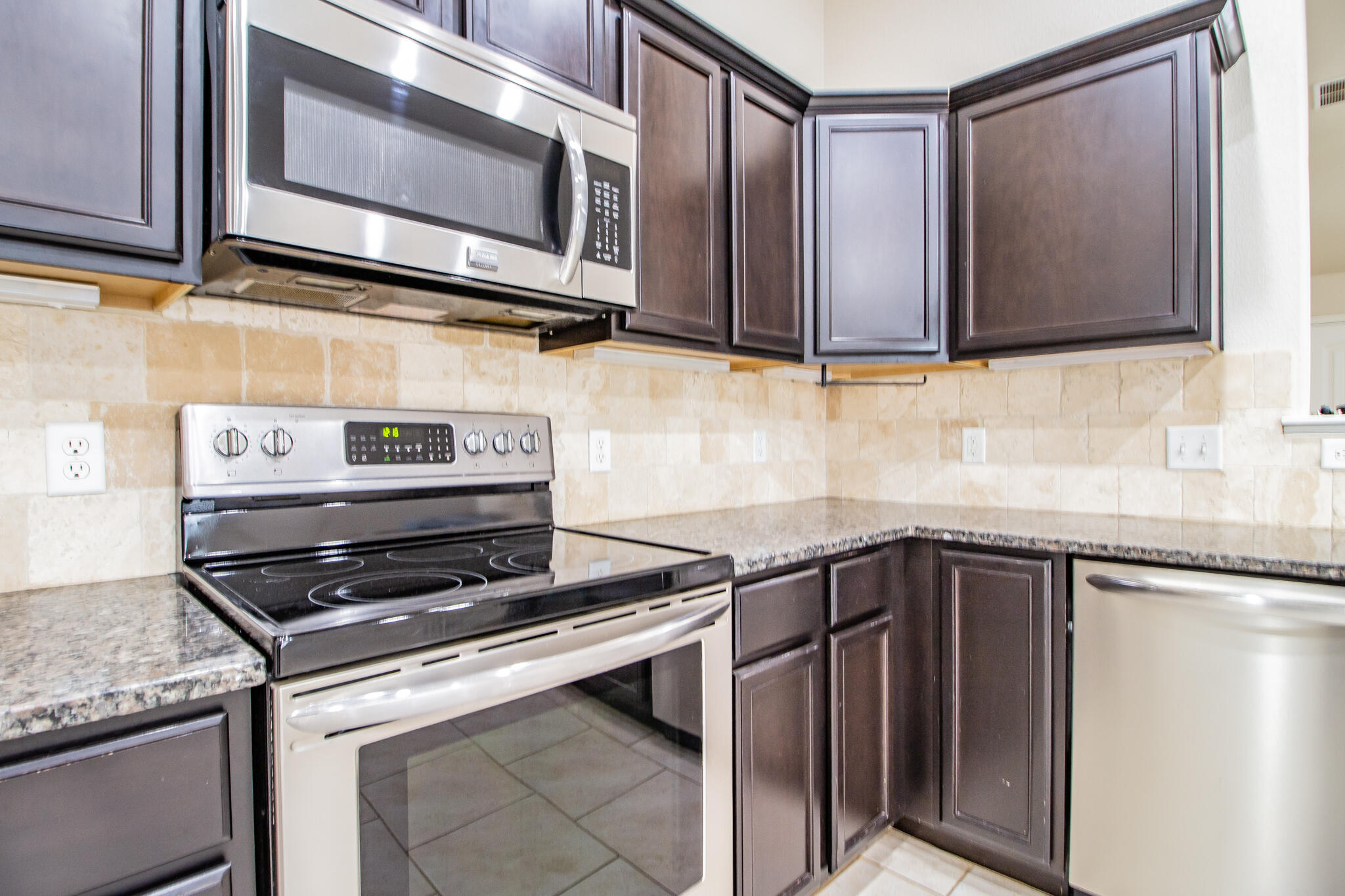 7409 101st Street Lubbock, TX 79424 - Photo 9 of 22 a kitchen with stainless steel appliances granite countertop a stove microwave and sink