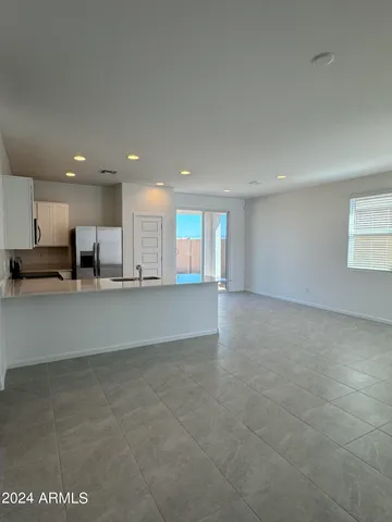 a view of kitchen with kitchen island white cabinets and refrigerator
