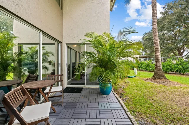 a porch with chairs and a yard