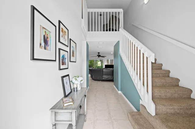 a view of staircase with lots of frames on wall and windows