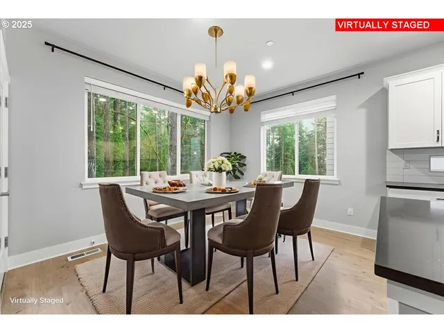 a view of a dining room with furniture a chandelier and wooden floor
