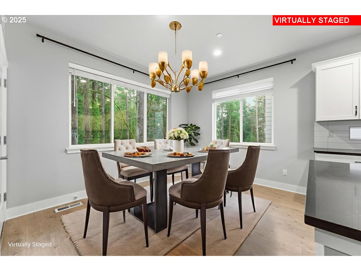 8565 Southwest 176th Avenue Beaverton, OR 97007 - Photo 8 of 39 a view of a dining room with furniture a chandelier and wooden floor