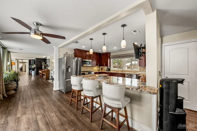 a kitchen with stainless steel appliances granite countertop wooden cabinets sink and stove