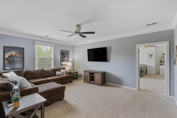 a living room with furniture a flat screen tv and a window