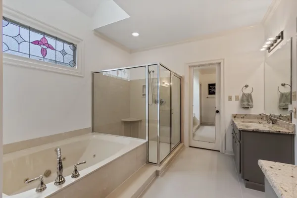 a bathroom with a tub a sink and mirror