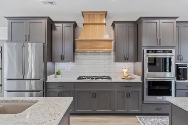a kitchen with stainless steel appliances granite countertop a sink stove and refrigerator