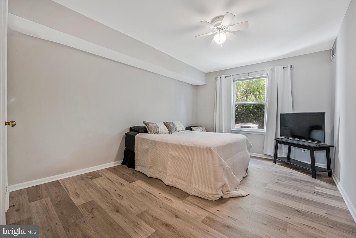 20334 Beaconfield Terrace, Unit 2 Germantown, MD 20874 - Photo 11 of 24 a spacious bedroom with a bed and a chandelier