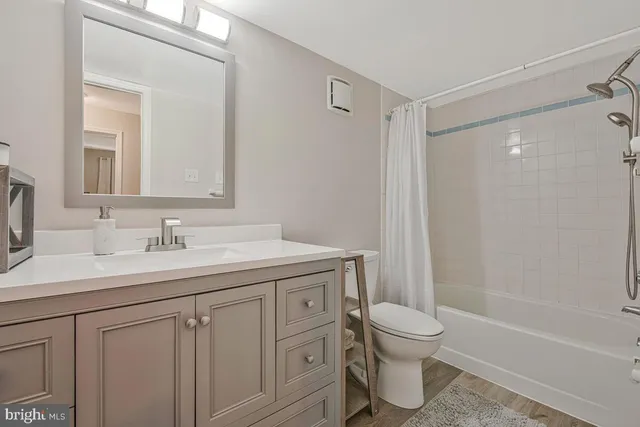 a bathroom with a granite countertop sink toilet a mirror and shower