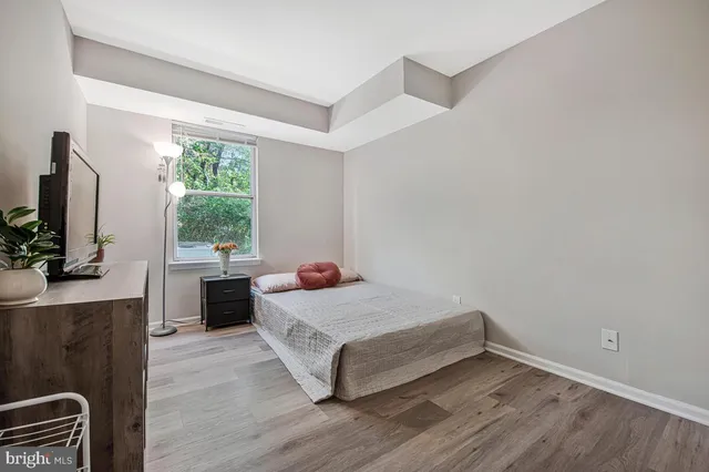 a room with a bed and a flat tv screen on a dresser