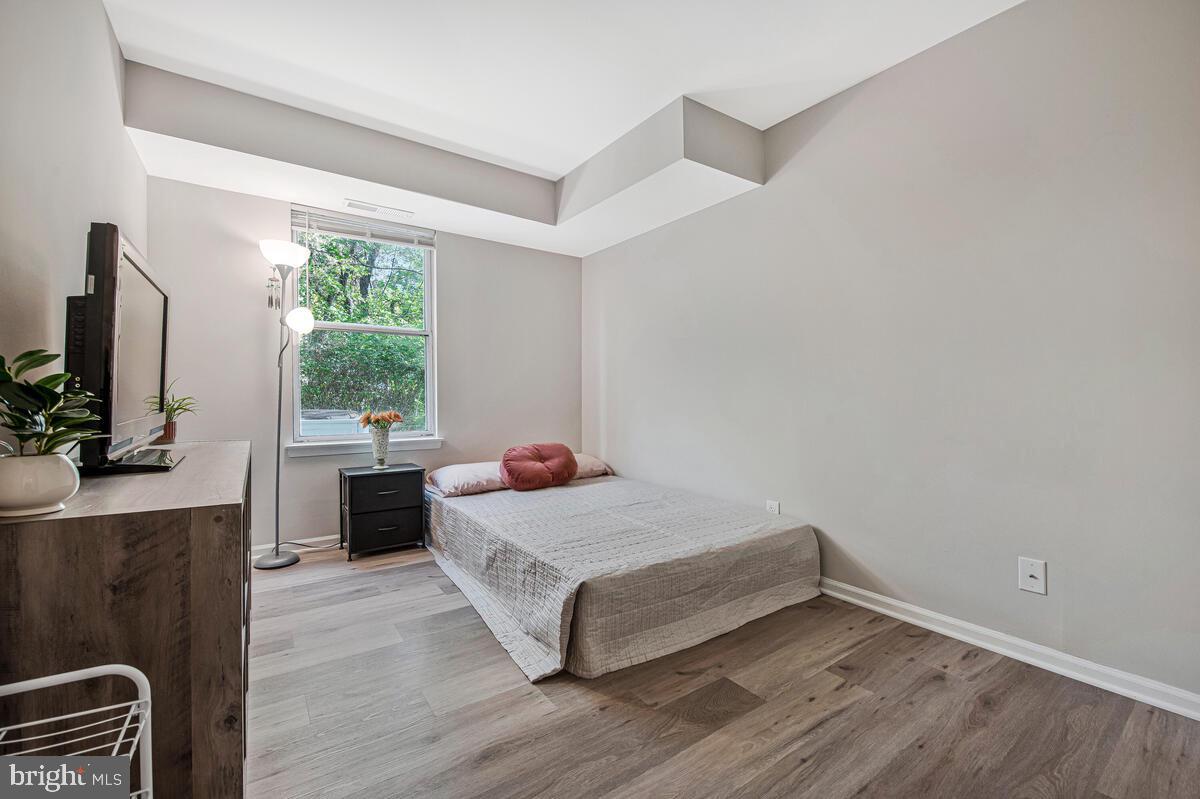 20334 Beaconfield Terrace, Unit 2 Germantown, MD 20874 - Photo 18 of 24 a room with a bed and a flat tv screen on a dresser