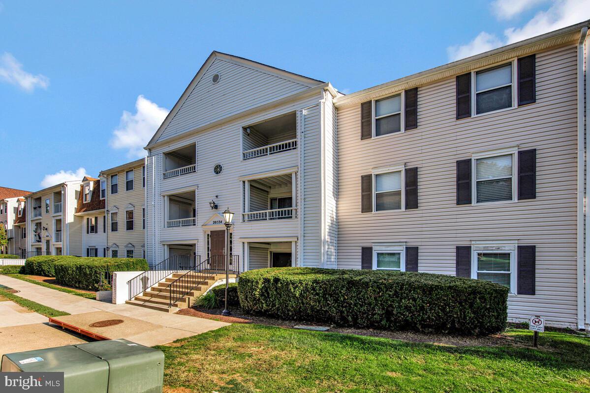 20334 Beaconfield Terrace, Unit 2 Germantown, MD 20874 - Photo 2 of 24 a front view of a building with a garden