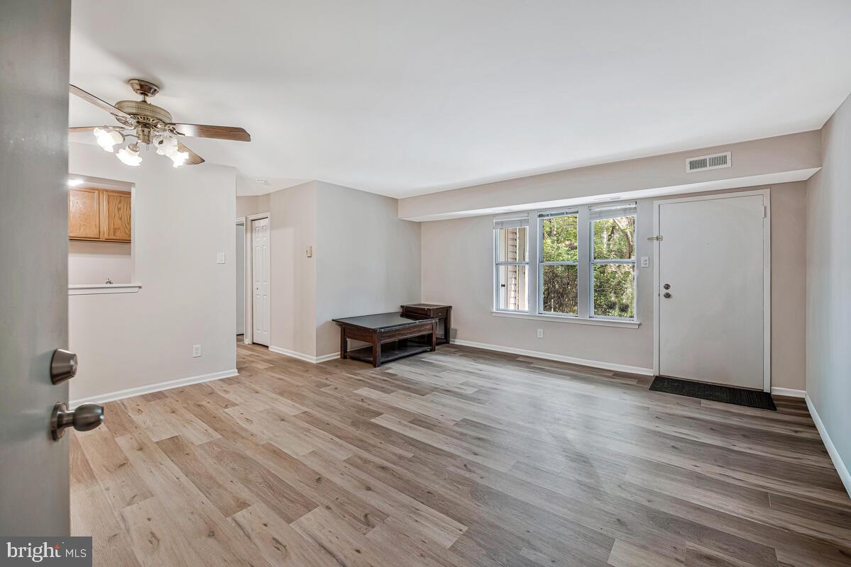 20334 Beaconfield Terrace, Unit 2 Germantown, MD 20874 - Photo 5 of 24 wooden floor in an empty room with a window