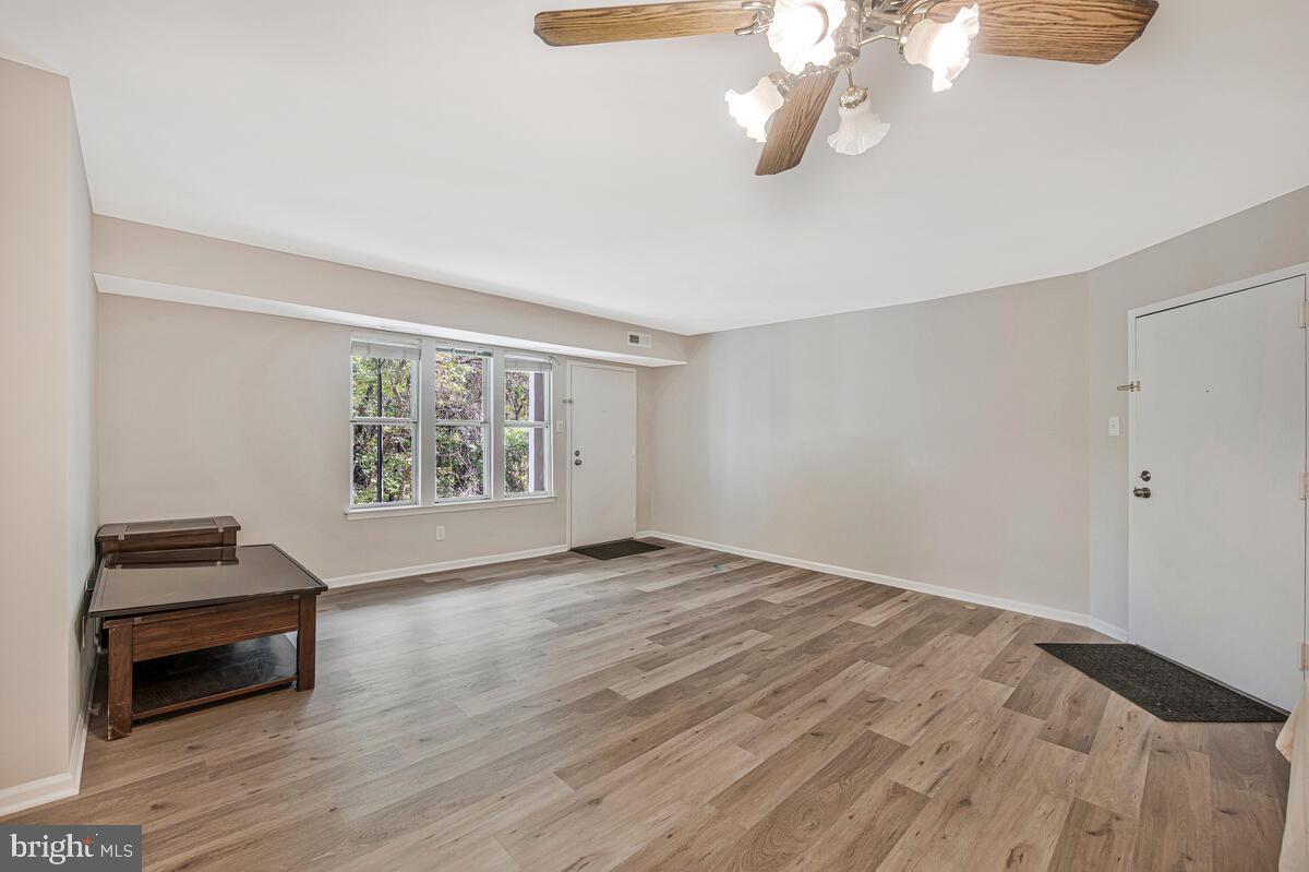 20334 Beaconfield Terrace, Unit 2 Germantown, MD 20874 - Photo 6 of 24 a view of an empty room with wooden floor and a window